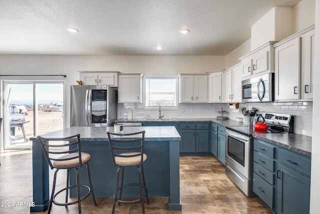 kitchen featuring appliances with stainless steel finishes, a textured ceiling, and a center island