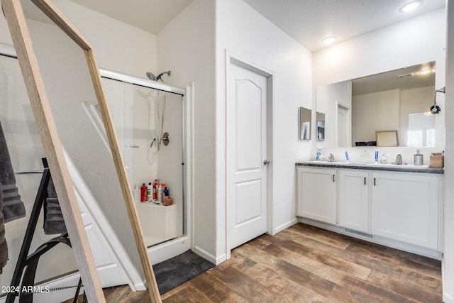 bathroom featuring vanity, wood-type flooring, and walk in shower