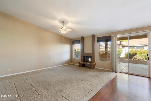 unfurnished living room with wood-type flooring, vaulted ceiling, and ceiling fan