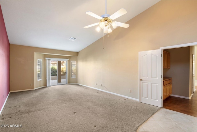 tiled spare room with ceiling fan and high vaulted ceiling