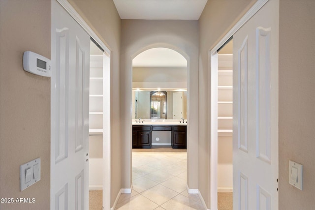 corridor with sink and light tile patterned floors