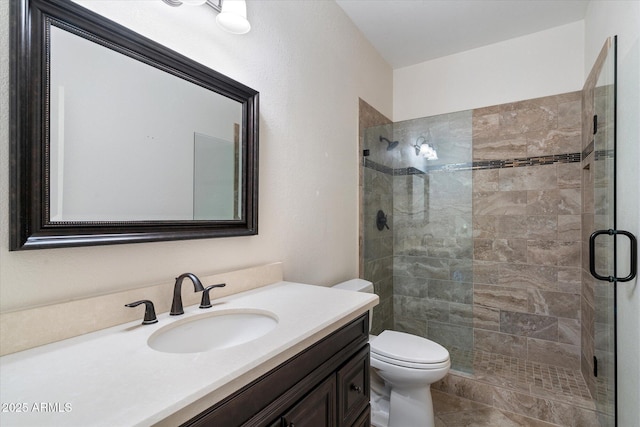 bathroom with vanity, a shower with shower door, and toilet