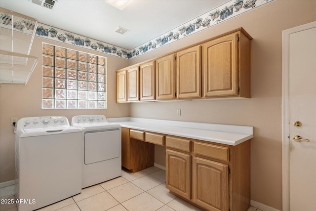 laundry room featuring light tile patterned floors, washing machine and dryer, and cabinets