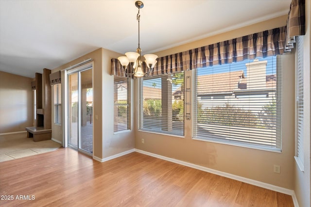 unfurnished dining area with hardwood / wood-style floors and a chandelier