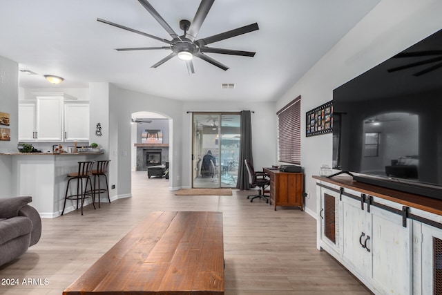 living room with ceiling fan and light hardwood / wood-style floors