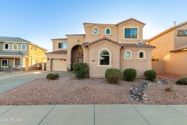 mediterranean / spanish-style house with a garage