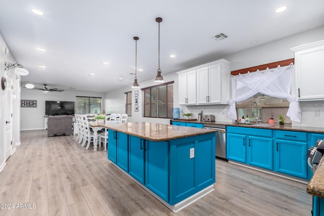 kitchen featuring stainless steel appliances, blue cabinets, a kitchen island, pendant lighting, and white cabinetry