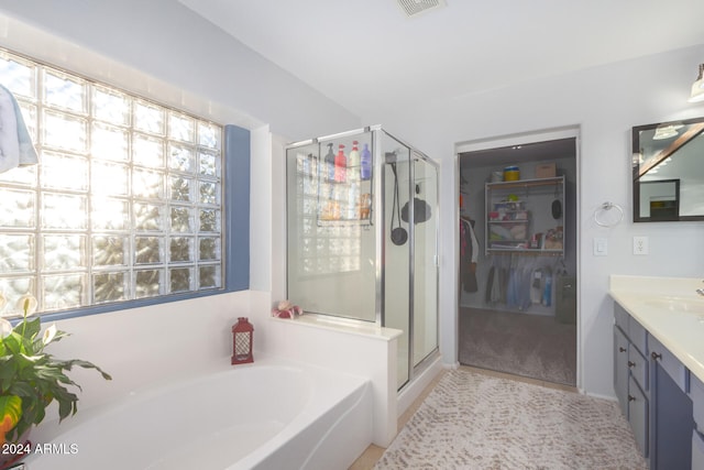 bathroom featuring vanity and independent shower and bath