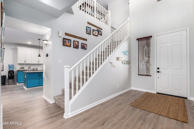 foyer entrance featuring a high ceiling and light wood-type flooring