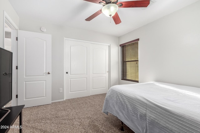 carpeted bedroom featuring ceiling fan and a closet