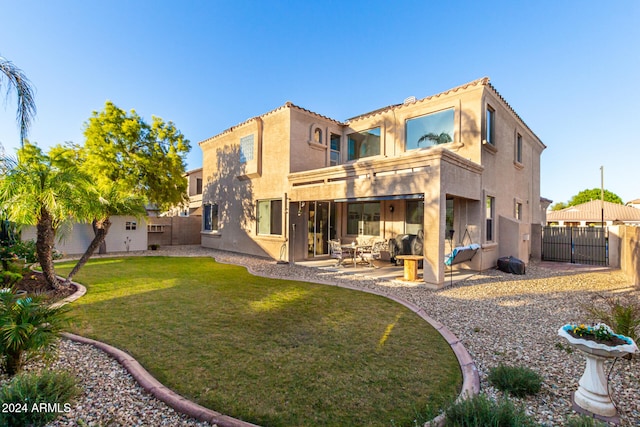 back of house featuring a patio area and a lawn