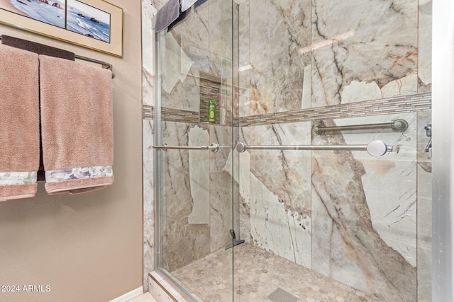 bathroom featuring a shower with door