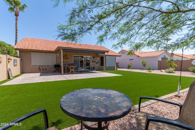 back of house with a patio area and a yard