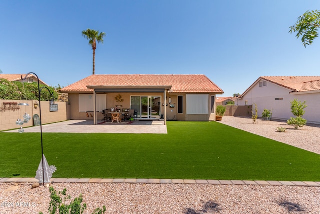 back of property with a lawn and a patio area