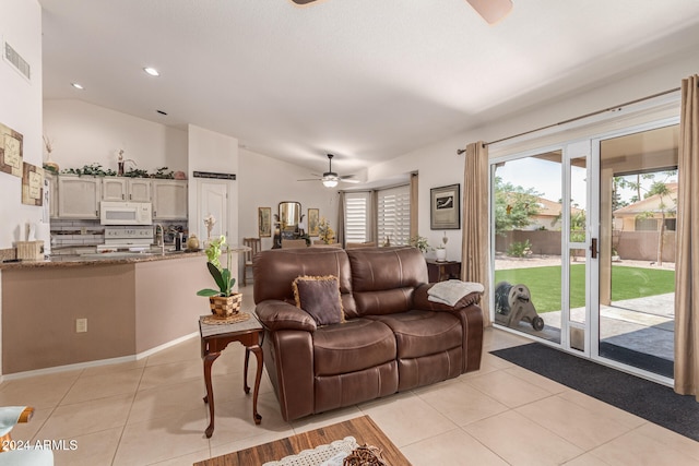 living room with vaulted ceiling, ceiling fan, and light tile patterned flooring