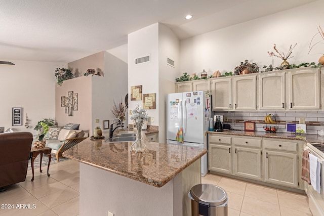 kitchen with backsplash, stone countertops, light tile patterned floors, and sink