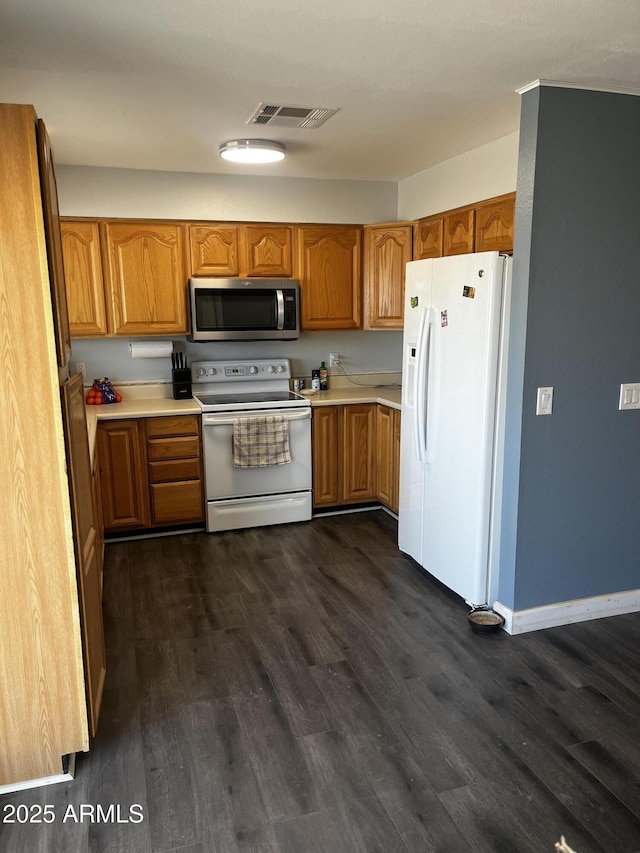 kitchen with white appliances and dark hardwood / wood-style flooring