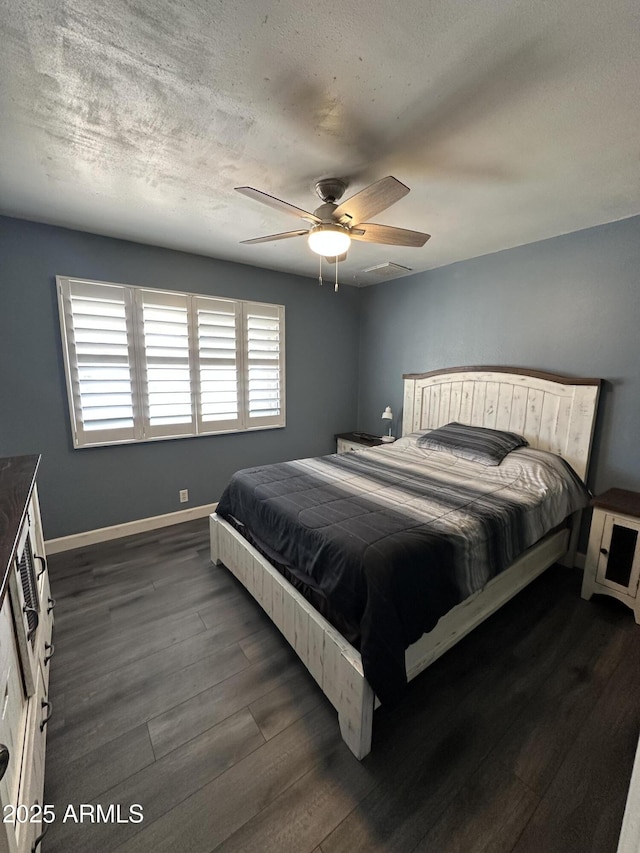 bedroom featuring dark hardwood / wood-style flooring, ceiling fan, and a textured ceiling