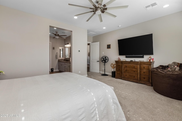 bedroom with connected bathroom, light carpet, and ceiling fan