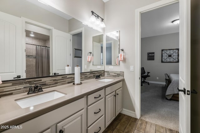 bathroom featuring tasteful backsplash, wood-type flooring, curtained shower, and vanity