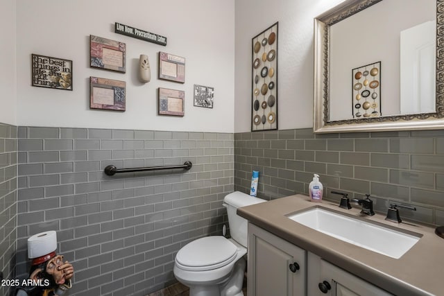 bathroom featuring vanity, toilet, and tile walls