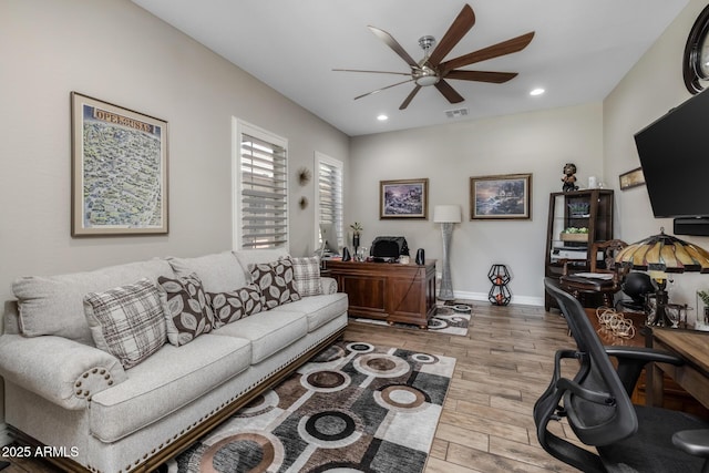 living room featuring ceiling fan and light hardwood / wood-style flooring