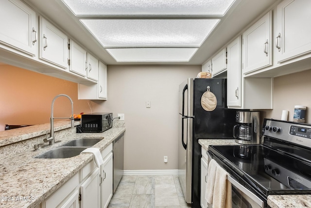 kitchen with white cabinetry, sink, stainless steel appliances, and light stone counters