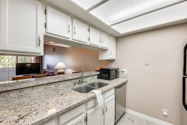 kitchen with dishwasher, white cabinets, sink, light tile patterned floors, and light stone counters