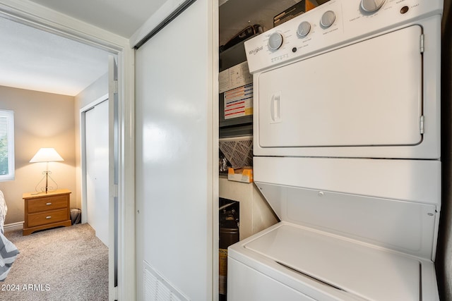 laundry area featuring carpet and stacked washer and clothes dryer