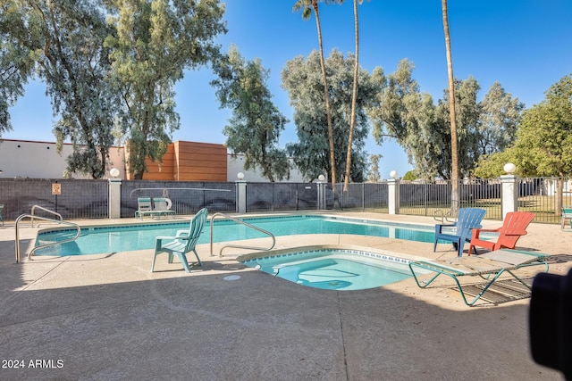 view of swimming pool featuring a patio area and a hot tub