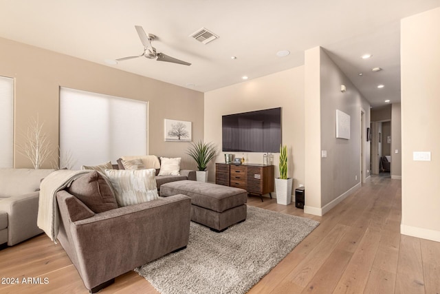 living room featuring light hardwood / wood-style flooring and ceiling fan