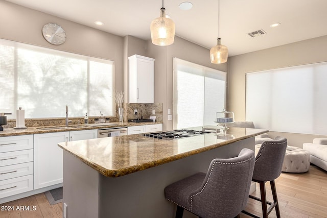 kitchen featuring pendant lighting, white cabinetry, sink, and appliances with stainless steel finishes