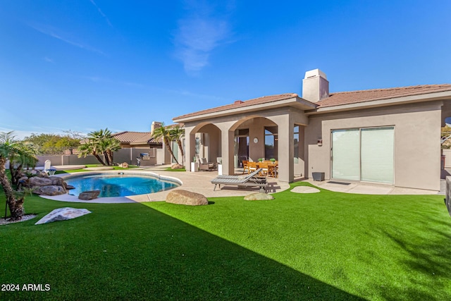 rear view of property with a yard and a patio area