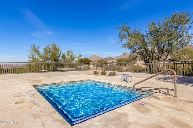 view of swimming pool featuring a mountain view and a patio