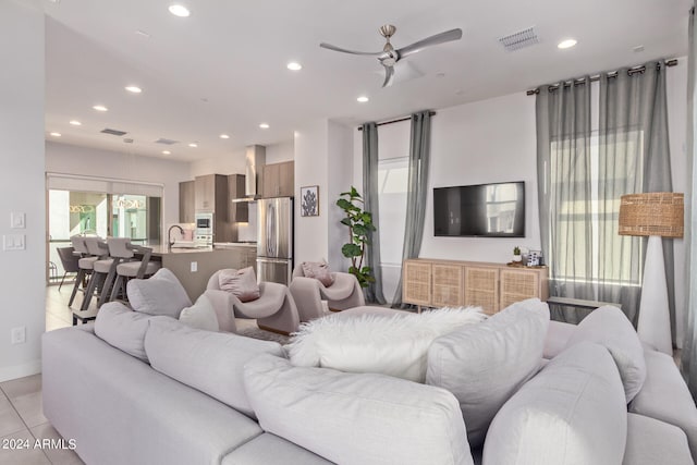 tiled living room featuring ceiling fan and sink