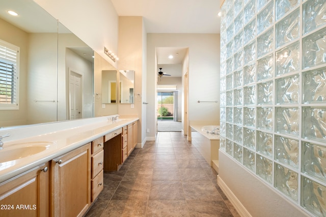 bathroom featuring ceiling fan, vanity, a bathing tub, and a healthy amount of sunlight