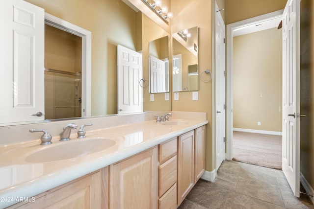 bathroom with tile patterned floors, a shower with shower door, and vanity