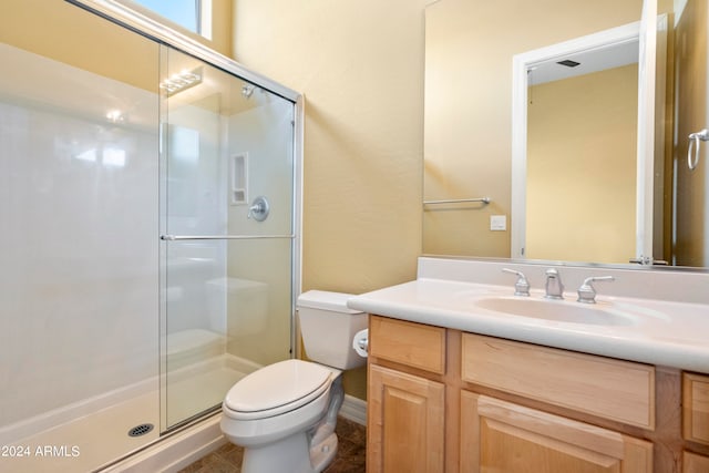 bathroom featuring a shower with door, vanity, and toilet