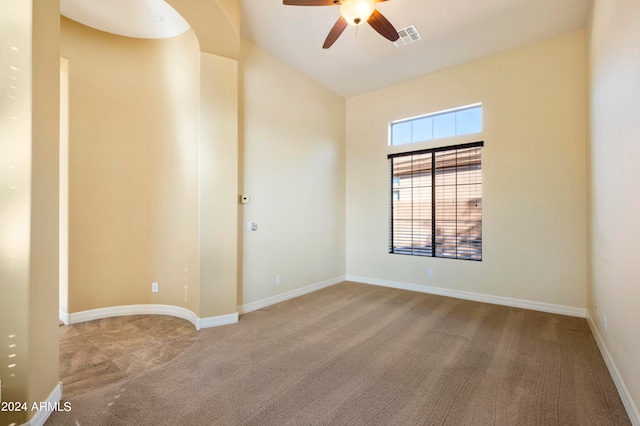 carpeted spare room featuring ceiling fan and lofted ceiling