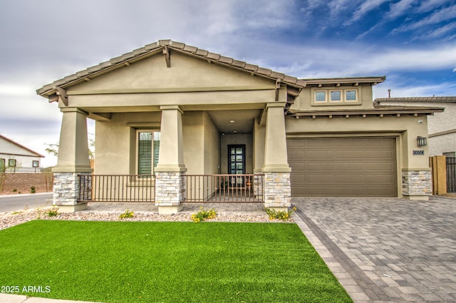 view of front of home with stone siding, a porch, decorative driveway, and stucco siding