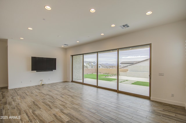 unfurnished living room featuring wood finished floors, visible vents, and recessed lighting