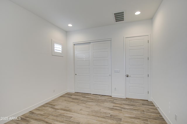 unfurnished bedroom with light wood-type flooring, visible vents, and baseboards