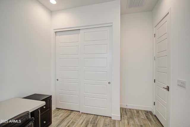 interior space featuring recessed lighting, baseboards, visible vents, and light wood finished floors