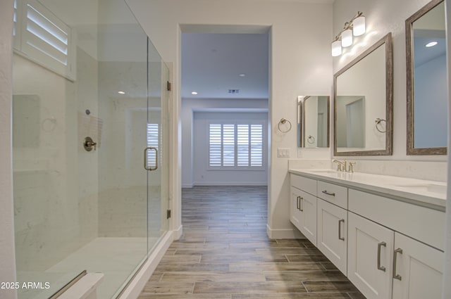 full bath featuring recessed lighting, wood finish floors, vanity, baseboards, and a stall shower