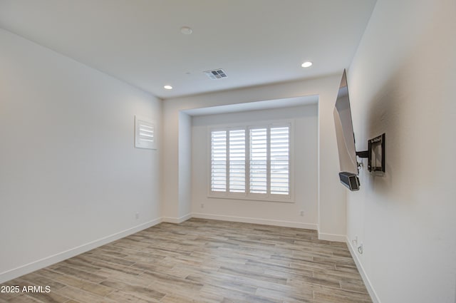 spare room with light wood-type flooring, visible vents, baseboards, and recessed lighting