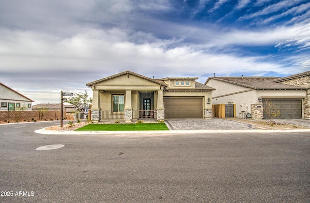 craftsman-style home with fence, stone siding, decorative driveway, a gate, and stucco siding