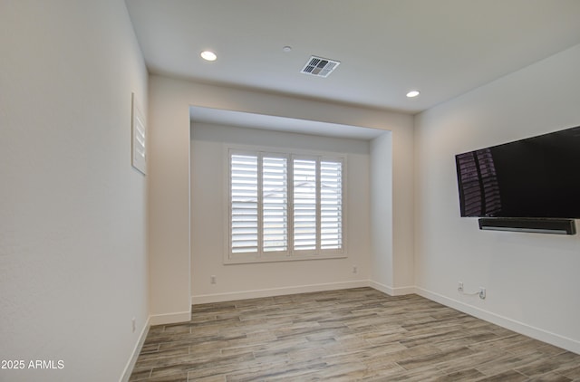 spare room with baseboards, visible vents, wood finished floors, and recessed lighting