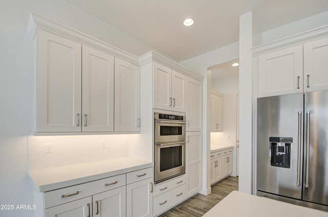 kitchen featuring recessed lighting, stainless steel appliances, white cabinetry, light countertops, and light wood-type flooring