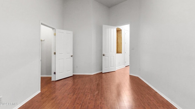 7171 W Quarter Horse Run, Coolidge, AZ 85128 - unfurnished room with baseboards, a high ceiling, and wood-type flooring