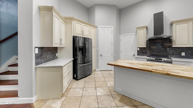 7171 W Quarter Horse Run, Coolidge, AZ 85128 - kitchen with stainless steel gas range oven, refrigerator with ice dispenser, cream cabinets, butcher block counters, and wall chimney range hood